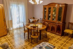 a dining room with a table and a china cabinet at A casa dei miei in Castelluccio +31 photos