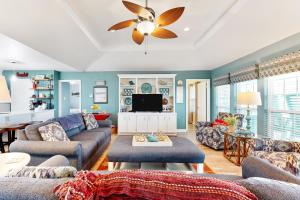 a living room with blue walls and a ceiling fan at Prime Gulf Views Large Deck Pet Paradise in Bolivar Peninsula