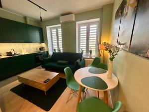a living room with a table and green chairs at Apartment Targowa L7 in Lublin