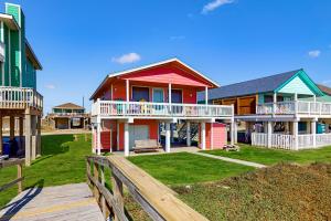 a row of houses on a beach with a wooden fence at Stunning Beachfront Beach Access Dog Haven in Hercules Offshore Heliport