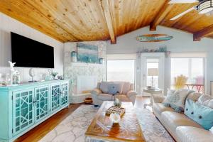 a living room with a couch and a tv at Stunning Beachfront Beach Access Dog Haven in Hercules Offshore Heliport