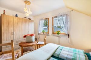 a bedroom with a bed and a chair and a window at Haus im Grünen in Oederan