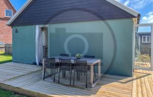 a patio with a table and chairs on a deck at Lovely Home In Thyborøn With Wifi in Thyborøn