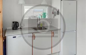 een witte keuken met een wastafel en een koelkast bij Lovely Home In Thyborøn With Wifi in Thyborøn