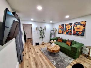 Brand New 1BR in Center City with Private Backyard في فيلادلفيا: غرفة معيشة مع أريكة خضراء وطاولة