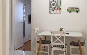 Nice Apartment In Podgora With Wifi في Kržanići: طاولة بيضاء صغيرة وكراسي في غرفة