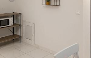 Nice Apartment In Podgora With Wifi في Kržanići: مطبخ أبيض مع ميكروويف على رف