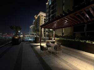 - une table et des chaises sur la terrasse la nuit dans l'établissement Stunning 1 Bed in Meydan, à Dubaï
