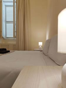 Una cama blanca en un dormitorio con ventana. en Harbour Lights, en Senglea
