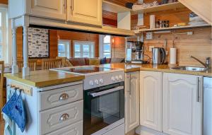 une cuisine avec des armoires blanches et un four à plaques de cuisson dans l'établissement 4 Bedroom Lovely Home In Leinøya, à Fosnavåg