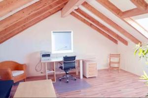 an attic room with a desk with a computer and chairs at Delfinia  +1 photo
