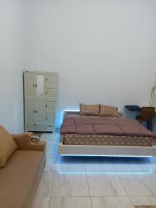 Un dormitorio con una cama, una cómoda y un sofá. en Touchsmart, en Lemahabang