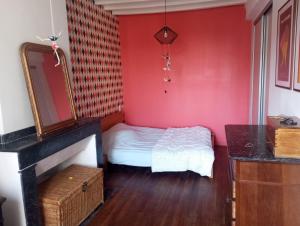 een slaapkamer met een bed en een rode muur bij Maison de maître in Bernac-Debat +2 foto's