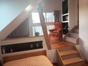 een kamer met een trap met een stoel en een raam bij Maison de maître in Bernac-Debat