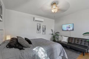 - une chambre avec un lit et un canapé en cuir dans l'établissement Casa Luna Studio-Peaceful Stay - 7 mins Airport, à Cielo Vista