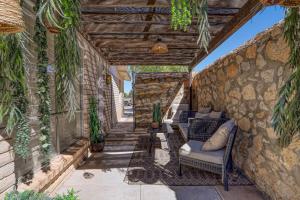 un patio avec des chaises et un mur en pierre dans l'établissement Casa Luna Studio-Peaceful Stay - 7 mins Airport, à Cielo Vista