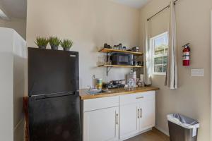 Cielo VistaCasa Sol Studio的厨房配有黑冰箱和白色橱柜。