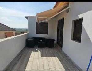 アルモドバル・デル・リオにあるEl capricho de Olgaの建物の上に椅子2脚とテーブルが置かれたバルコニー