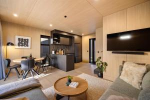 a living room with a couch and a table at Luxury Tupu Ora Villa Queenstown in Queenstown Airport