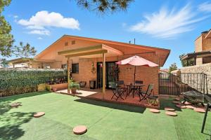 een huis met een patio met een tafel en een parasol bij Casa de al Abuelita in Montoya