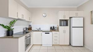 una cucina con elettrodomestici bianchi e frigorifero bianco di Sundown on Grafton St a Cairns