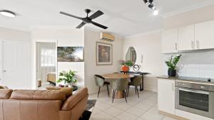 un soggiorno con un divano e un ventilatore a soffitto di Sundown on Grafton St a Cairns