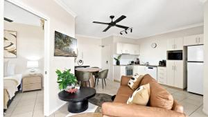 un soggiorno con divano e cucina di Sundown on Grafton St a Cairns Altre 25 foto