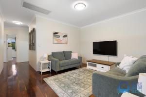 a living room with two chairs and a flat screen tv at Mandurah Luxury on Sutton in Mandurah