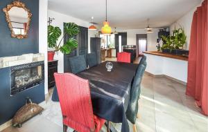 ein Esszimmer mit einem schwarzen Tisch und roten Stühlen in der Unterkunft Stunning Home In Jonquières in Jonquières