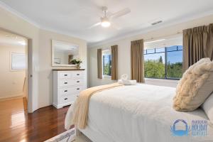 a bedroom with a white bed and a window at Mandurah Luxury on Sutton in Mandurah