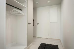 a white hallway with a door and a rug at Spacious Apartment for 5 with Sauna in Masala