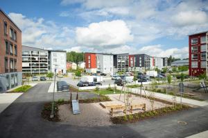 a parking lot with a park with a bench and buildings at Spacious Apartment for 5 with Sauna in Masala