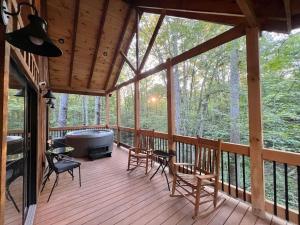 a screened in porch with chairs and a hot tub at The Lazy Maple in Red River Gorge in Rogers