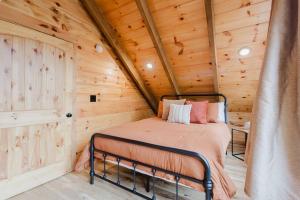 a bedroom with a bed in a wooden cabin at The Lazy Maple in Red River Gorge in Rogers