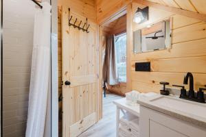 a bathroom with a shower and a sink and a door at The Lazy Maple in Red River Gorge in Rogers +34 photos