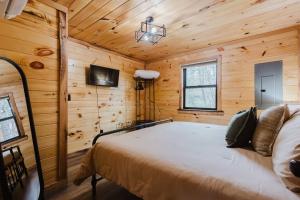 Un dormitorio con una cama en una cabaña de madera. en Timber Pines at Red River Gorge, en Rogers