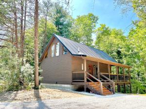 Una cabaña en el bosque con techo de metal en Timber Pines at Red River Gorge, en Rogers