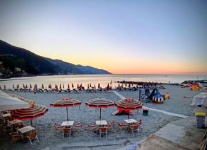 a beach with chairs and umbrellas and the ocean at Affittacamere Alle 5 Terre in Monterosso al Mare