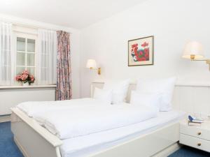 1 cama blanca en un dormitorio blanco con ventana en Enenhoog-Flugente, en Kampen