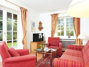 sala de estar con sillas rojas y TV en Enenhoog-Flugente, en Kampen