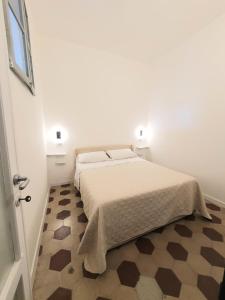 萨萨里Charlie's Apartment -Centro Storico的一间白色的卧室，配有一张床和格子地板 更多15张照片
