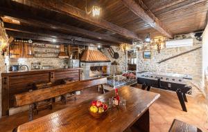 una cocina con mesas de madera y bancos en una habitación en Lovely Home In Donji Bitelic, en Donji Bitelić