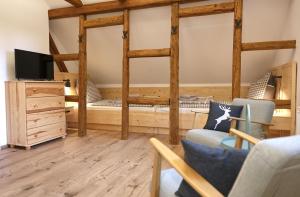 a room with two bunk beds and a tv at Berghaus zum Hirsch in Gehlberg