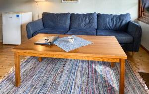 2 Bedroom Stunning Home In Byxelkrok في بيكسلكروك: طاولة قهوة في غرفة معيشة مع أريكة زرقاء