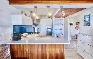 a kitchen with white cabinets and a counter top at Charmant Appartement Vue Mer in Saint-Georges-de-Didonne