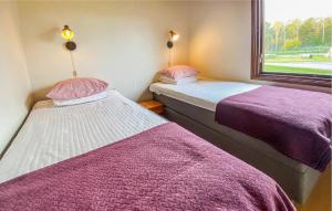 ビクセトルゥにあるAmazing Home In Byxelkrok With Wifiの部屋の窓の横に置かれた2つのベッド