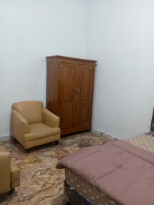 LemahabangTouchsmart的一间卧室配有一张床、一把椅子和一个橱柜