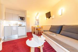 a living room with a couch and a table with a laptop at Résidence La Daille - Val-d'Isère in Val dʼIsère +10 photos