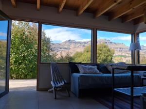 - un salon avec un canapé et une vue sur les montagnes dans l'établissement Bella vista el manzano, à San Martín de los Andes