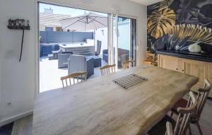 une salle à manger avec une grande table et des chaises en bois dans l'établissement Amazing Home In Cléder With Wifi, à Penar Pors